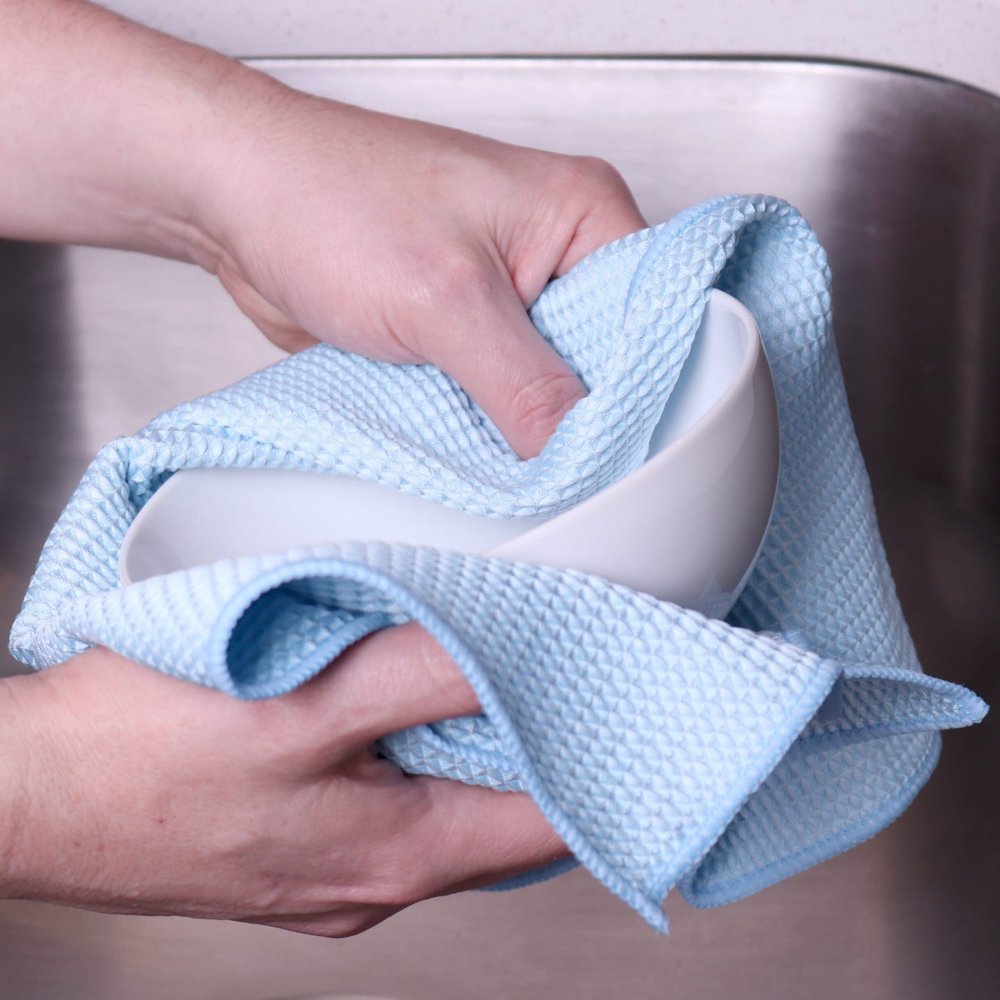 blue waffle-weave towel cleaning a bowl